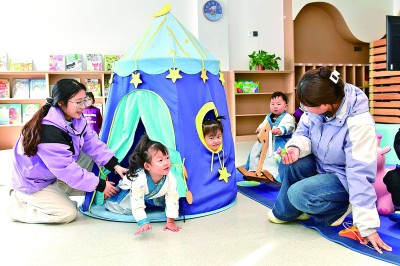 在山東鄆城縣夢馬貝兒托育早教中心，托育老師陪孩子們做游戲。新華社發(fā)