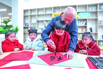 浙江諸暨市，一位老人在“老幼共融，雙齡共養(yǎng)”活動上指導(dǎo)孩子們寫福字。新華社發(fā)