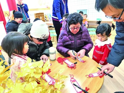 北京西城區(qū)小小椿芽托育園內(nèi)，老年人與孩子們在卡片上書寫祝福。資料圖片