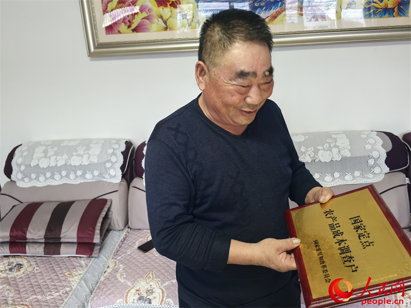 李強(qiáng)向記者展示他獲得的“國(guó)家定點(diǎn)農(nóng)產(chǎn)品成本調(diào)查戶”牌匾。人民網(wǎng)記者 陳新輝攝